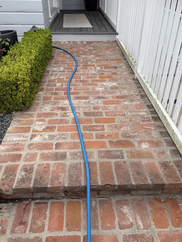 Brick walkway dark with dirt and algae before cleaning