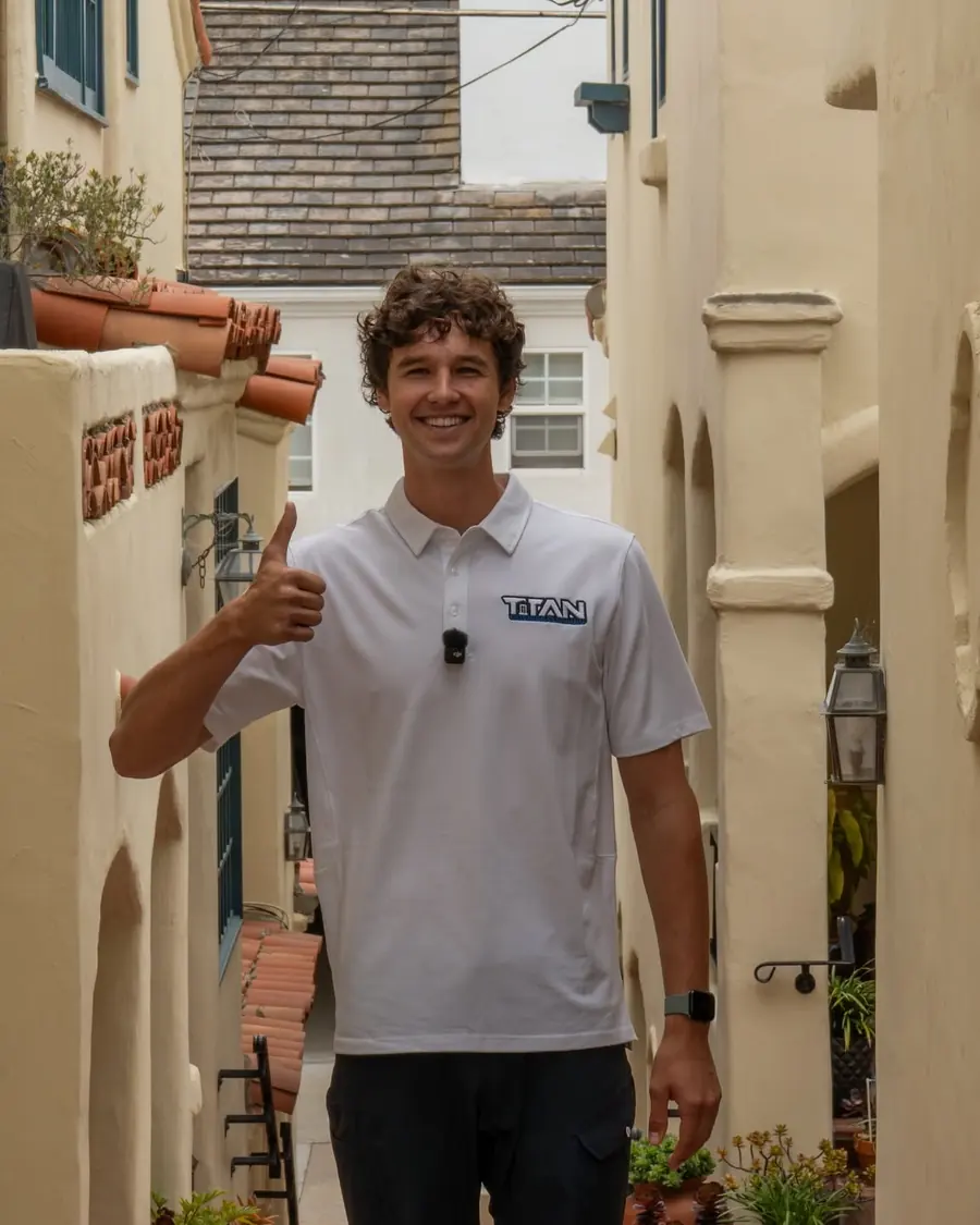 Titan crew member giving a thumbs up outside a stucco home
